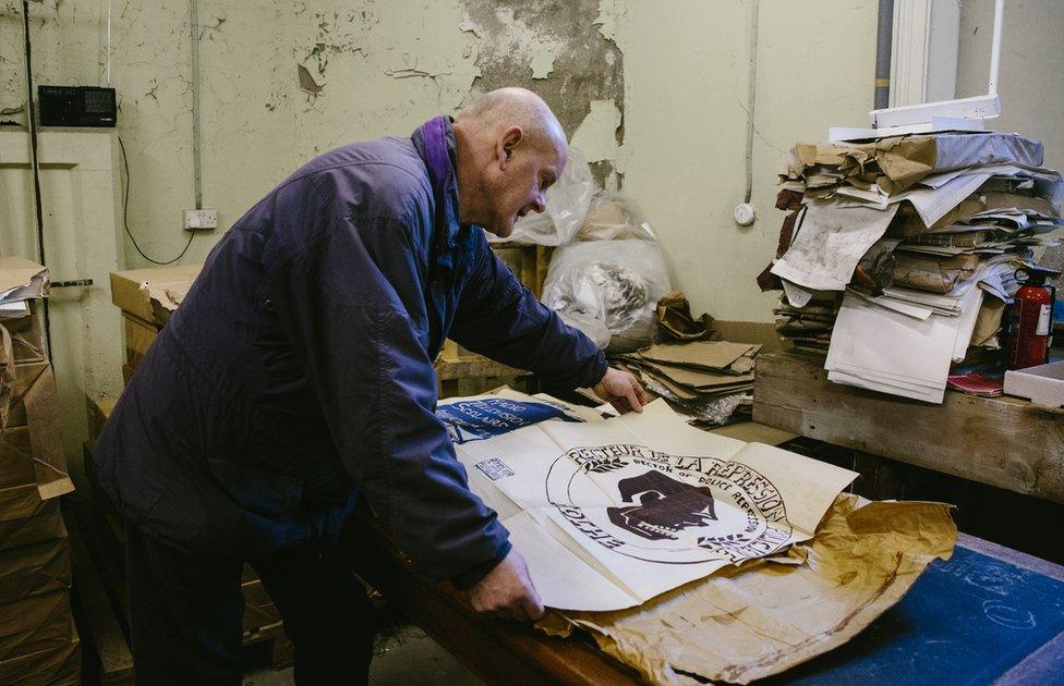 Oliver Dobson looking at Atelier Populaire poster