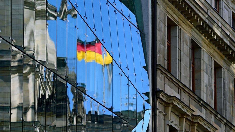 The Reichstag building, seat of the German lower house of Parliament, the Bundestag, is reflected in an glass facade in Berlin