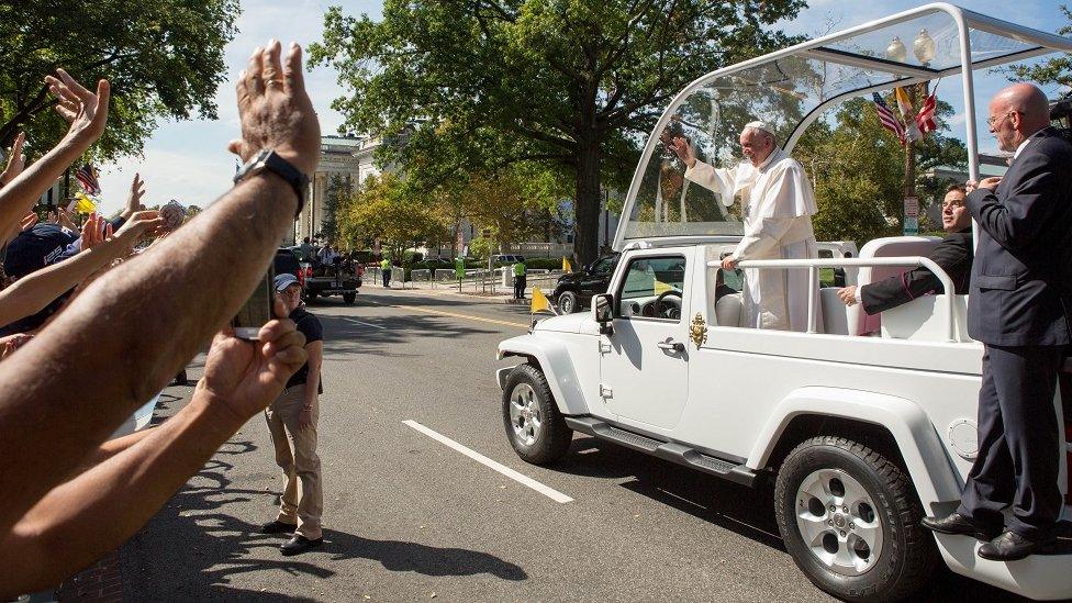 The Pope greets crowds from inside the Popemobile