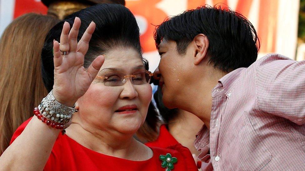 Vice-presidential candidate "BongBong" Marcos whispers to his mother, former First Lady and Congresswoman Imelda Marcos, at an event where he announced his candidacy, in Manila on 10 October