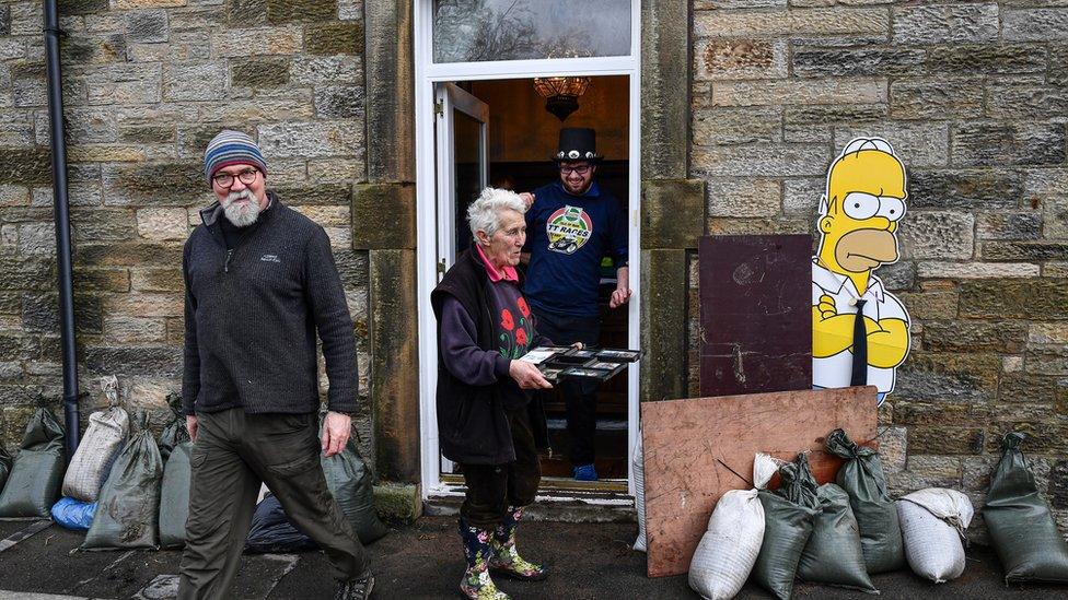 People begin the clean-up following yesterday's flooding in Newcastleton, Scotland.