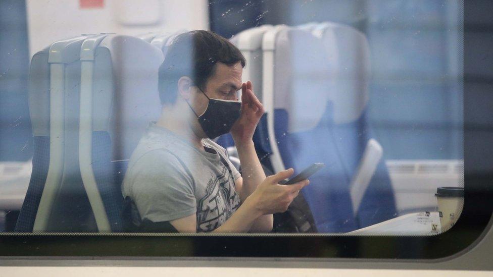 A man wearing a mask on a train