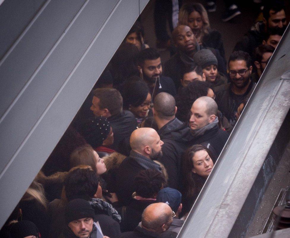 Commuters at Stratford railway station try to board an Overground train