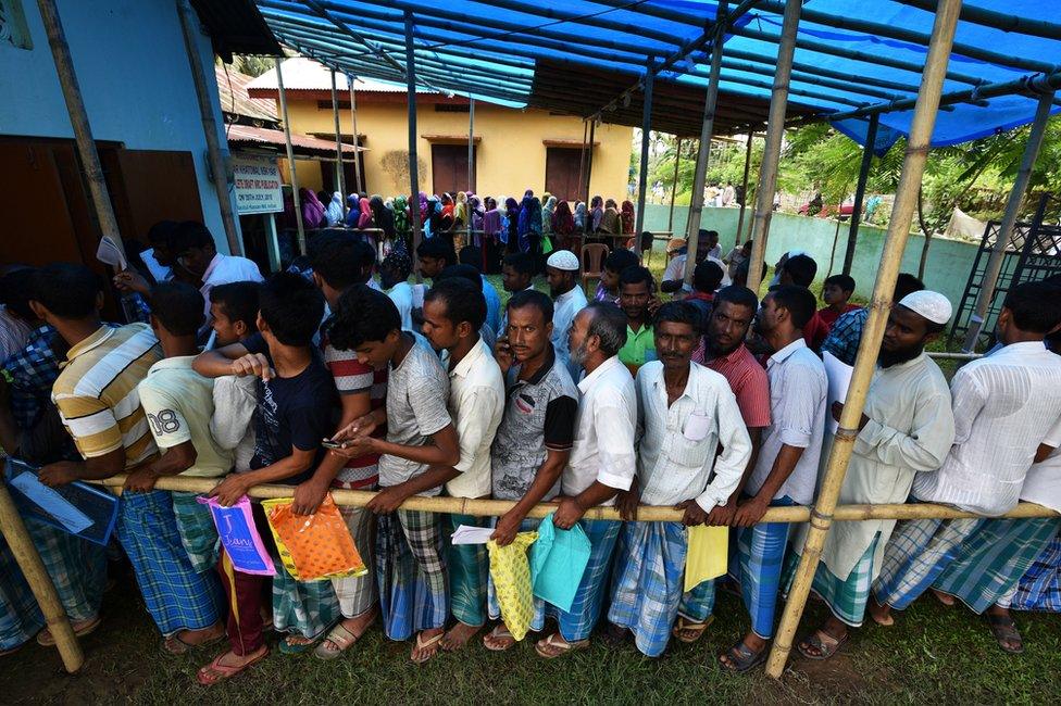 People wait in queue to check their names on the draft list at the National Register of Citizens centre at a village in Assam on 30 July 2018.