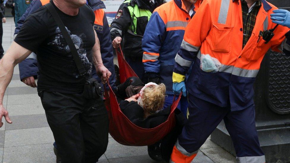 An injured person is helped by emergency services outside Sennaya Ploshchad metro station following explosions in St Petersburg, Russia, 3 April 2017