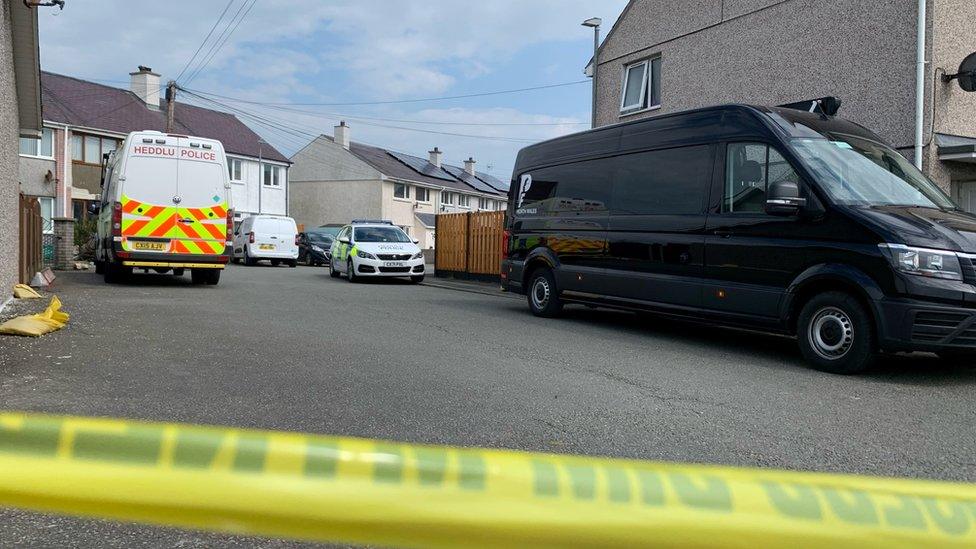 Police van with police tape cordoning the road