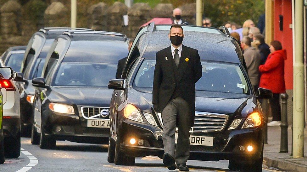 Mourners lined the street as the three hearses passed