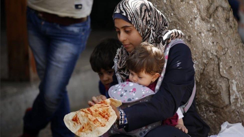 Syrian refugees sit a sidewalk in Izmir, Turkey, on 10 September 2015. W