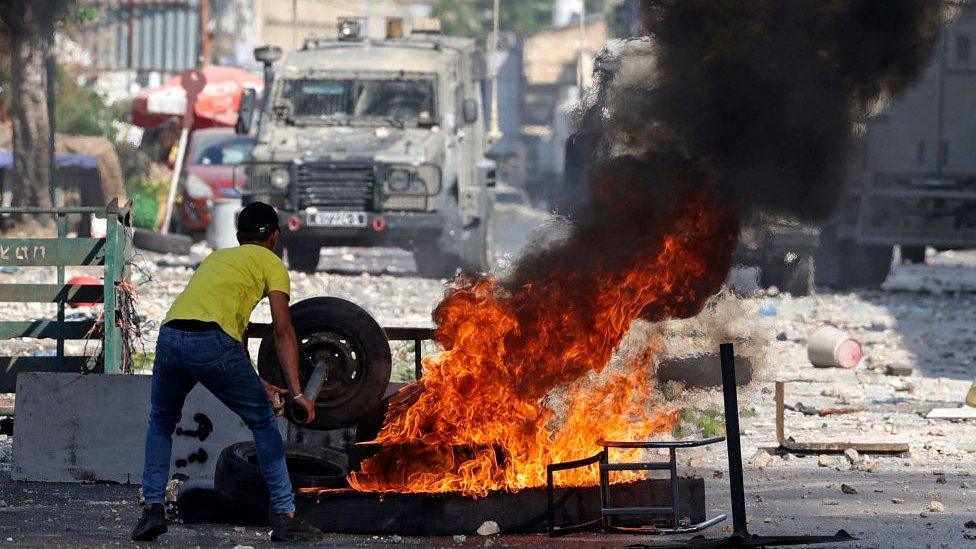 Palestinian burns tyre in Nablus (file photo)