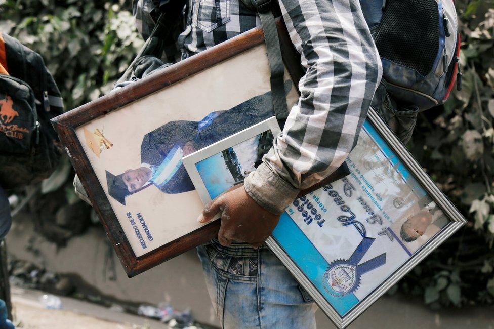 A man carries personal belongings at an area affected by the eruption