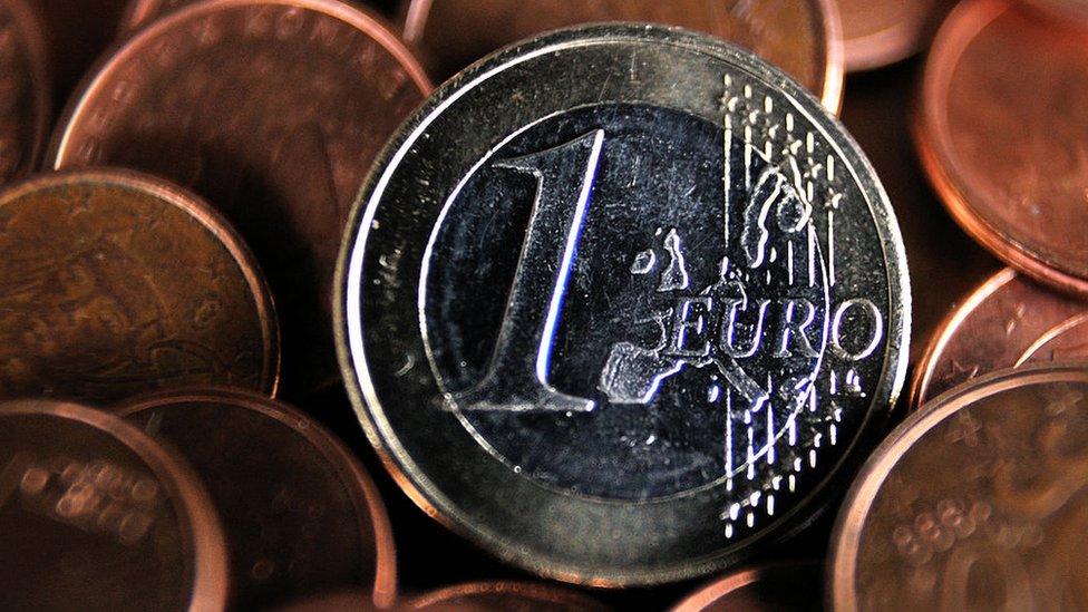 A one-euro coin on a pile of euro cents