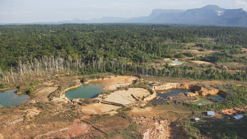 Forest destruction caused by mining gold deposits. Soil is blasted with powerful jets of water, causing chemical pollution which has a major impact on the rain forest environment, Venezuela, South America - stock photo