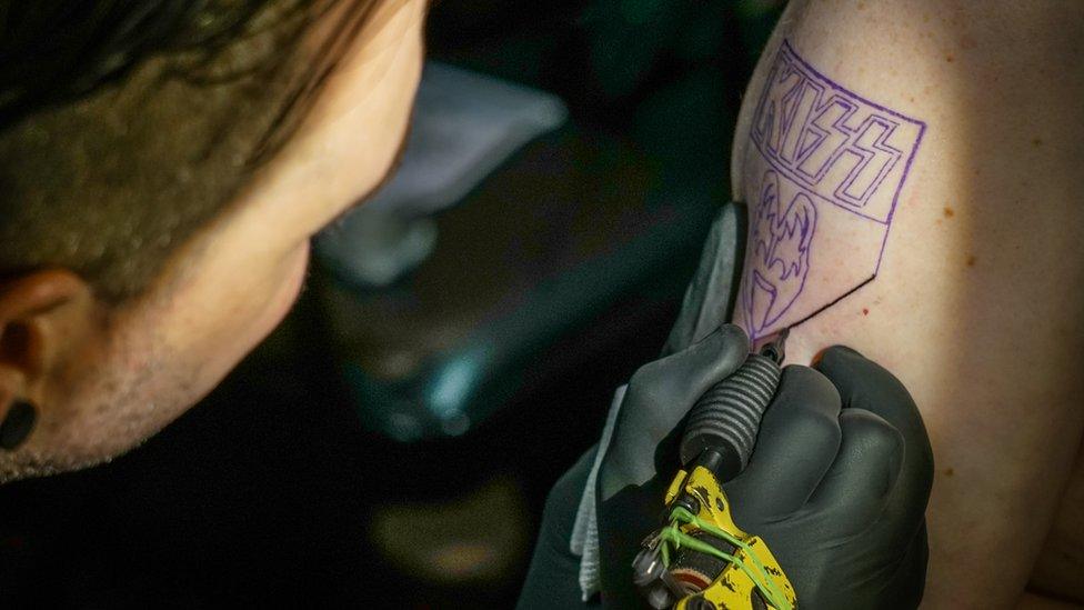 A Kiss fan gets a tattoo on a Kiss Kruise