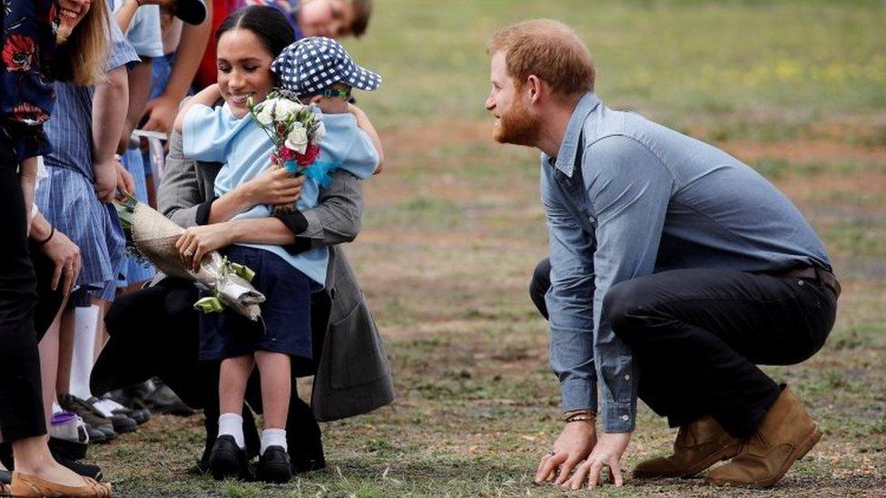 Prince Harry and Meghan, Duchess of Sussex, hug Luke Vincent, five, after arriving at Dubbo airport, Dubbo, Australia