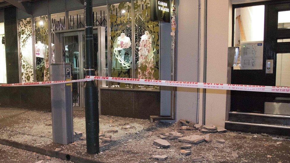 Debris from buildings are seen on a sidewalk past a cordon line in Wellington