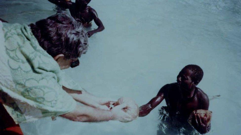 TN Pandit handing a coconut to a Sentinelese man