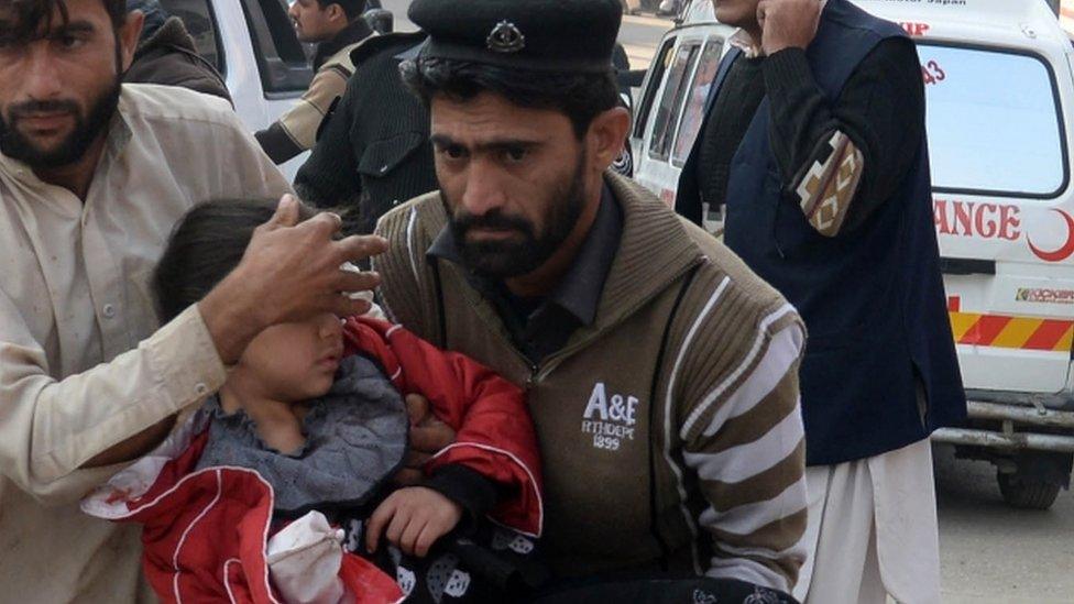 Injured school girl being carried following an attack by Taliban gunmen on the Army Public School in Peshawar, December 2014