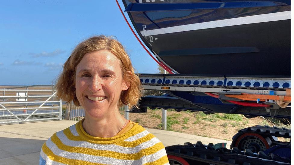 Blonde haired woman in front of blue RNLI boat