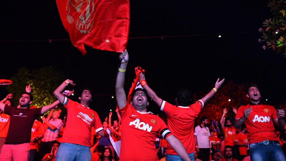 Supporters of Manchester United cheer during the English Premier League football match between Manchester United and Arsenal in New Delhi on May 17