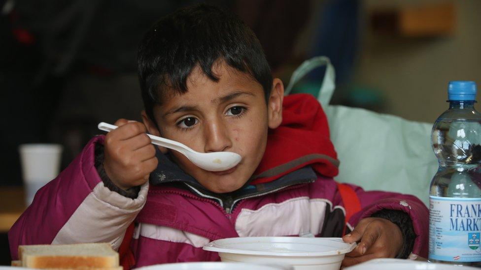 A young boy eats soup at a shelter for migrants who had arrived on buses chartered by Austrian authorities and will likely continue towards the nearby border to Germany on October 17, 2015 in Kollerschlag, Austria