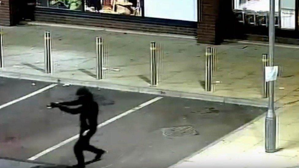 Man on CCTV holding gun