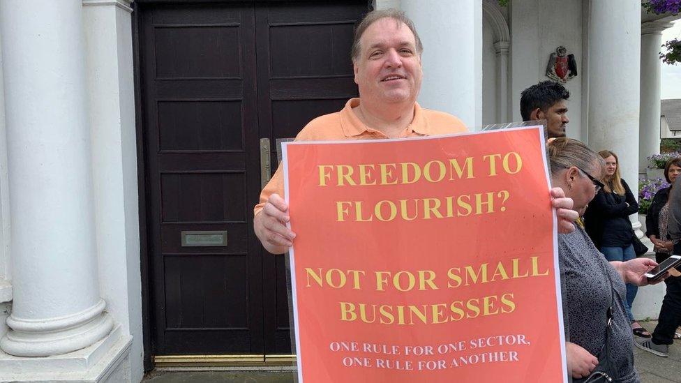 John Large holding placard