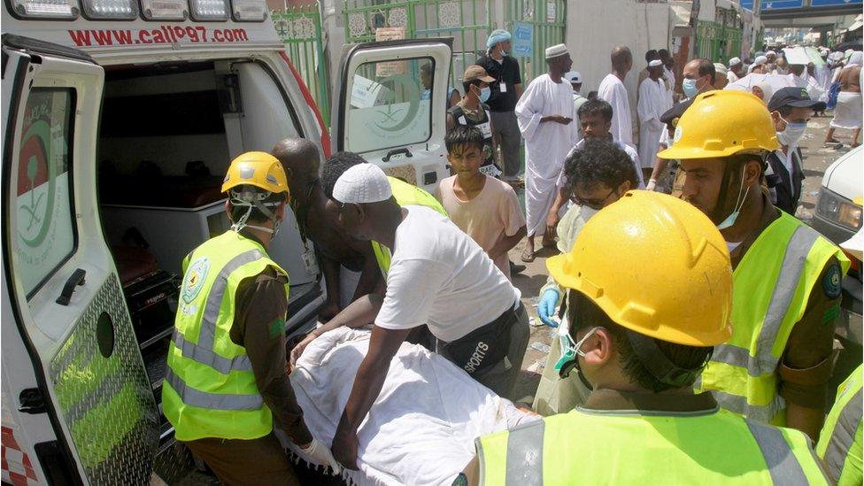 Saudi emergency workers at Hajj pilgrimage load a wounded person into an ambulance