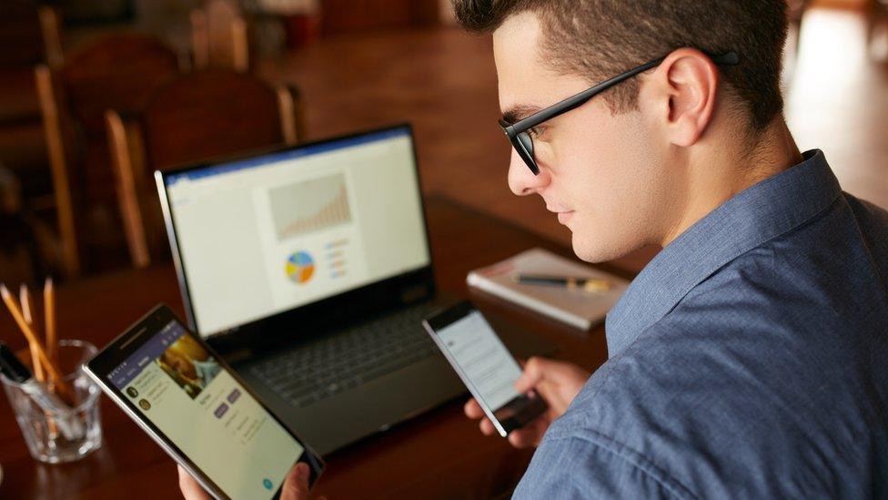 A man using three devices