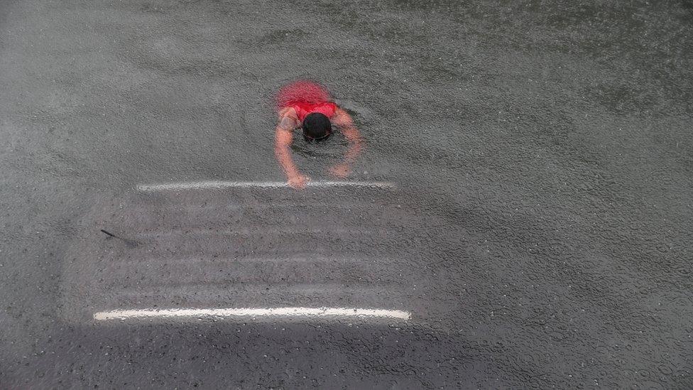 Firefighters work in a flooded underground tunnel