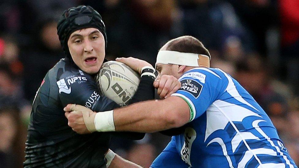 Ospreys fly-half Sam Davies is held by Dragons lock Rynard Landman