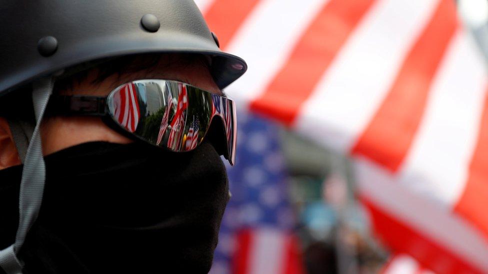 A protester is seen next to a U.S. flag in Central, Hong Kong, China September 8, 2019.