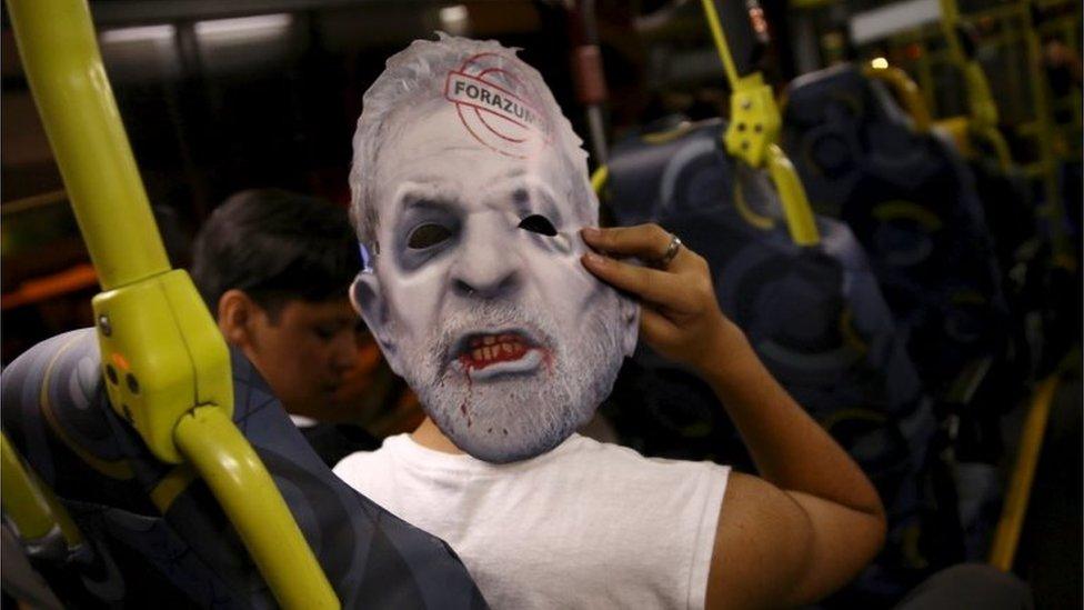 A demonstrator inside a bus wears a mask depicting Brazil's former president Luiz Inacio Lula da Silva after a protest against Brazil"s President Dilma Rousseff, which is part of nationwide demonstrations calling for her impeachment, in Sao Paulo, Brazil, on 13 March, 2016