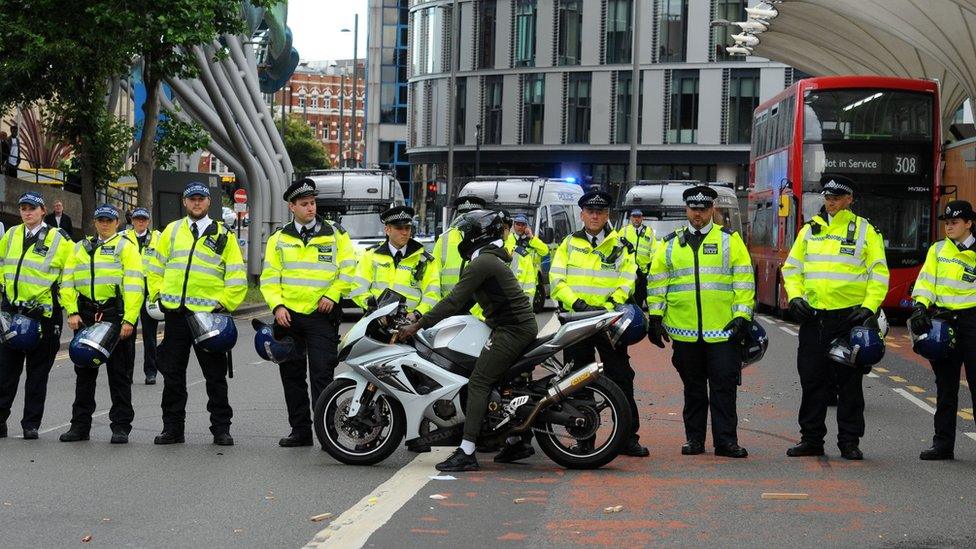 A motorcyclist in front of police officers