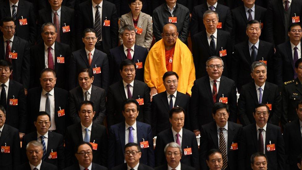 Delegates stand during the national anthem at the end of a plenary session of the National People's Congress in March 2019