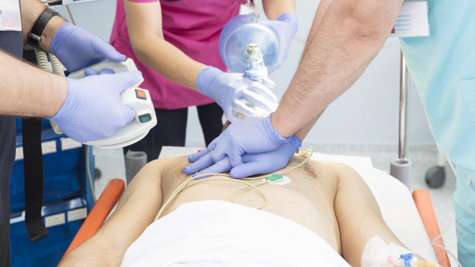 An unconscious man being treated by doctors