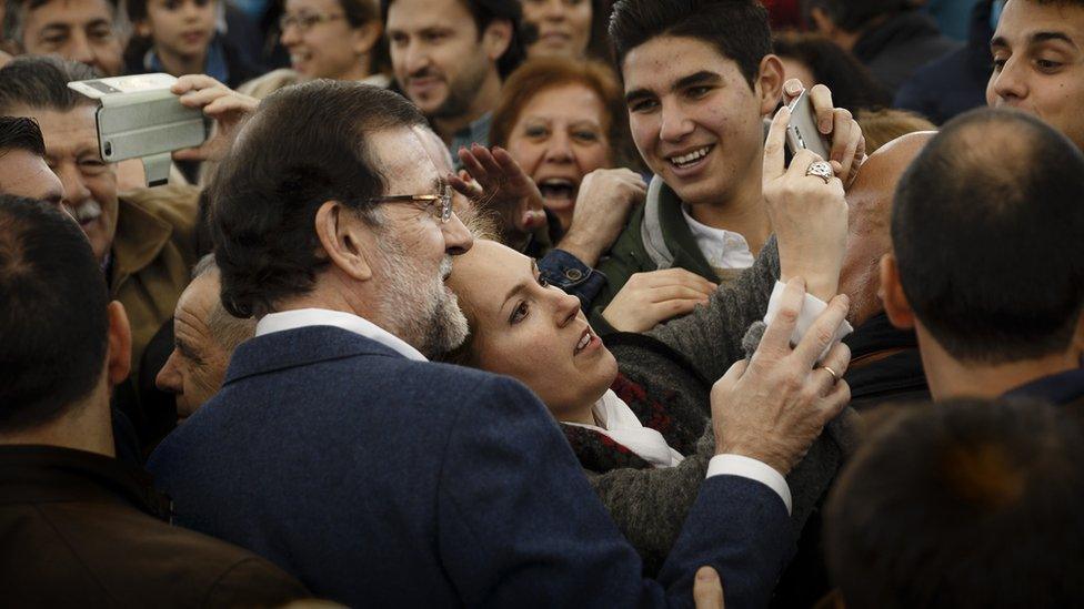 Supporters of Mariano Rajoy pose with him during a campaign rally (13 Dec)