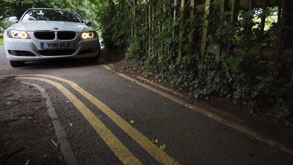 a bmw on the road with the yellow lines