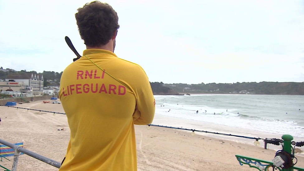 Lifeguard patrolling at St Brelades beach