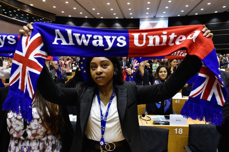 A member of the Group of the Progressive Alliance of Socialists and Democrats in the European Parliament holds a scarf depicting the European Union and the Union Jack flags during a ceremony at the Europa Building in Brussels.