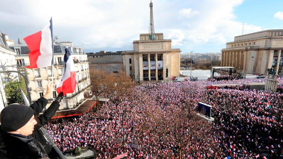 Supporters holding French flags gather for a rally in support of French presidential election candidate for the right-wing Les Republicains (LR) party Francois Fillon