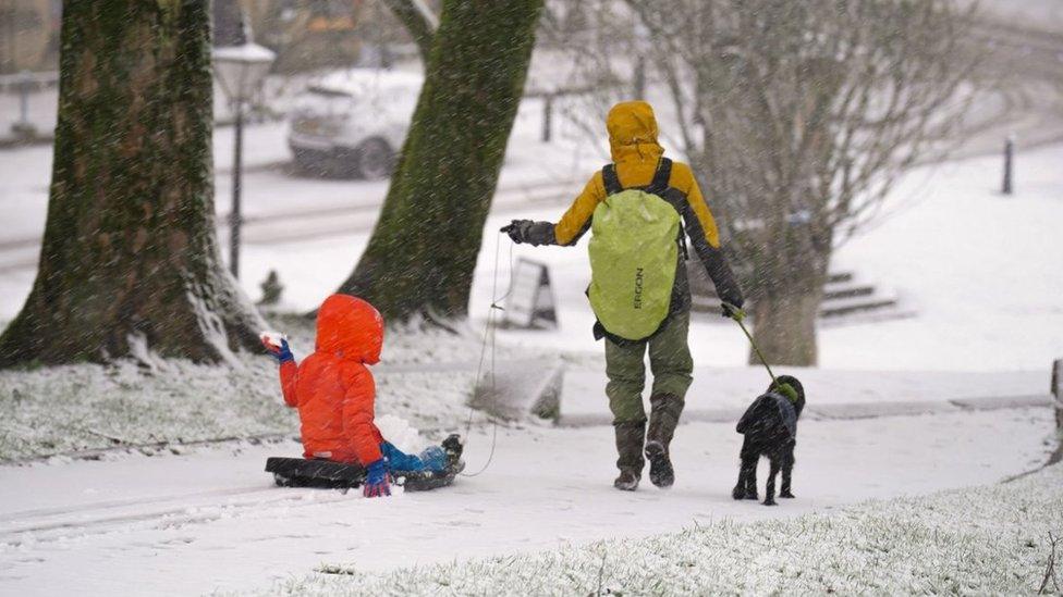 A child rides a sled in Buxton