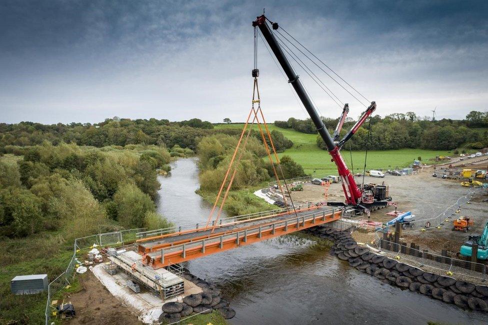 The installation of the new 124 tonne temporary bridge that will provide access over the River Caldew to contractors