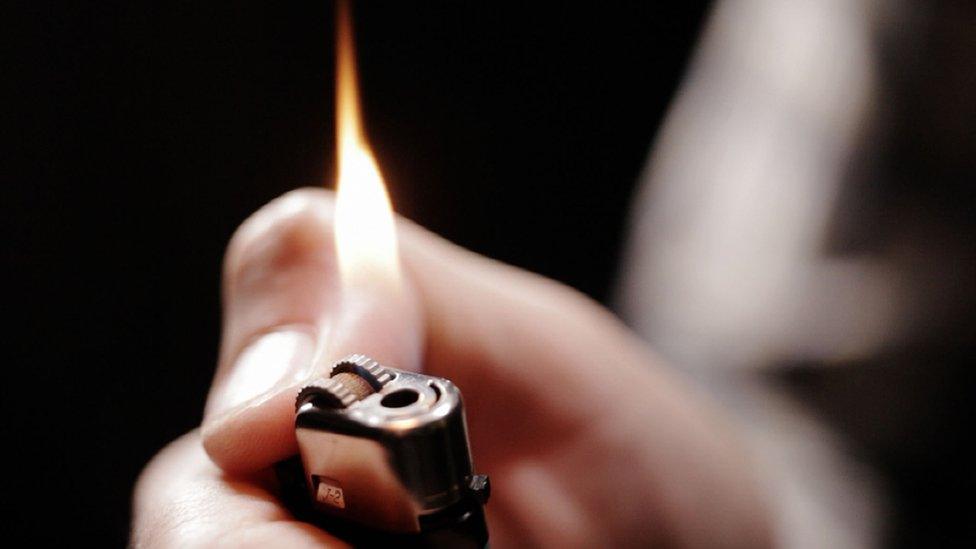 Person igniting disposable lighter