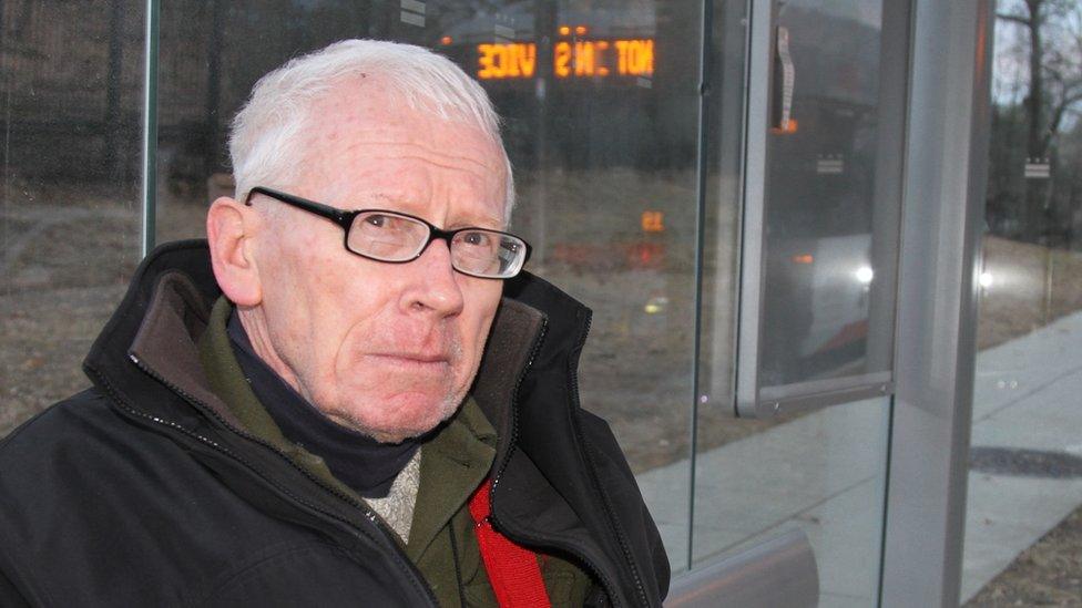 John in the bus stop opposite the embassy.