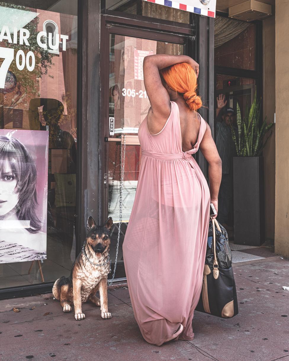 A woman with a dog standing outside a hairdressers