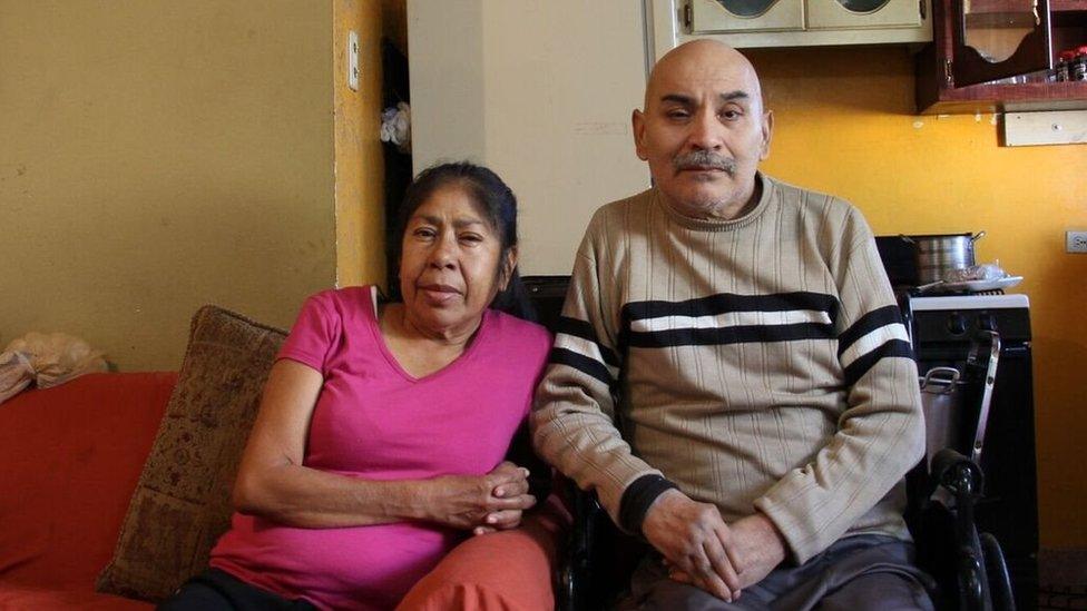 Miguel Angel Esparza and Patricia Moreno sitting in their home