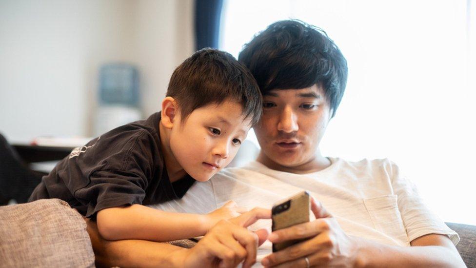 child and father on smartphone