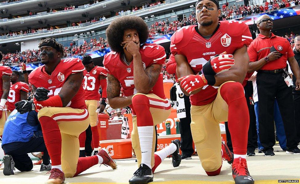 Eli Harold, Colin Kaepernick and Eric Reid kneel before a 49ers match