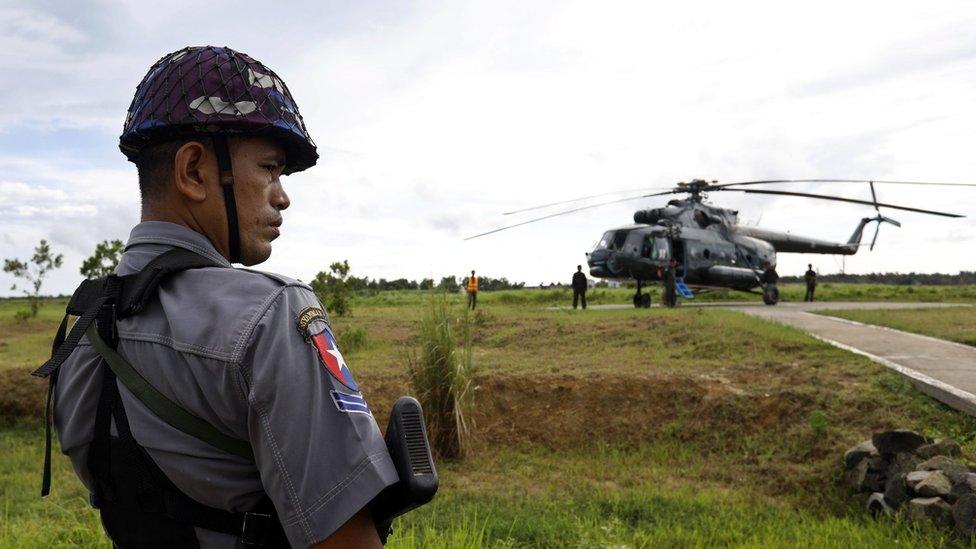 Police stands guard near the military transport helicopter at Maungdaw township in Rakhine State, western Myanmar, 27 September 2017