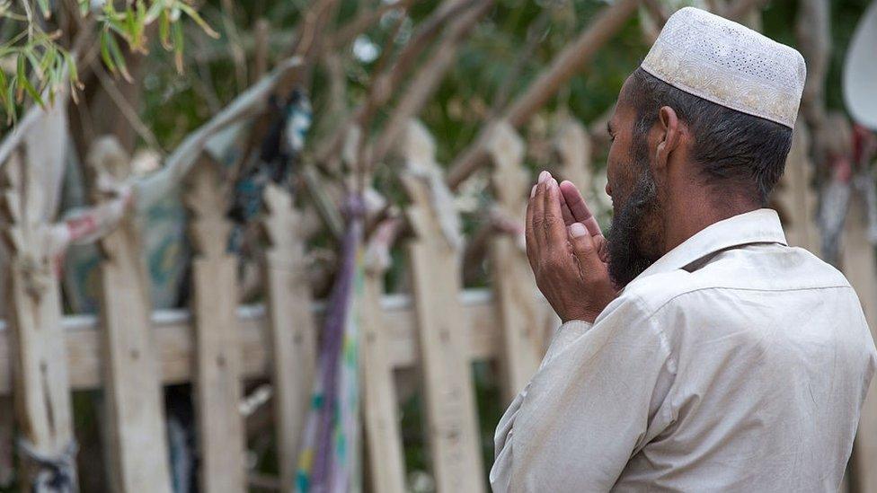 Man praying at imam Asim tomb in the Taklamakan desert, Xinjiang Uyghur Autonomous Region, China